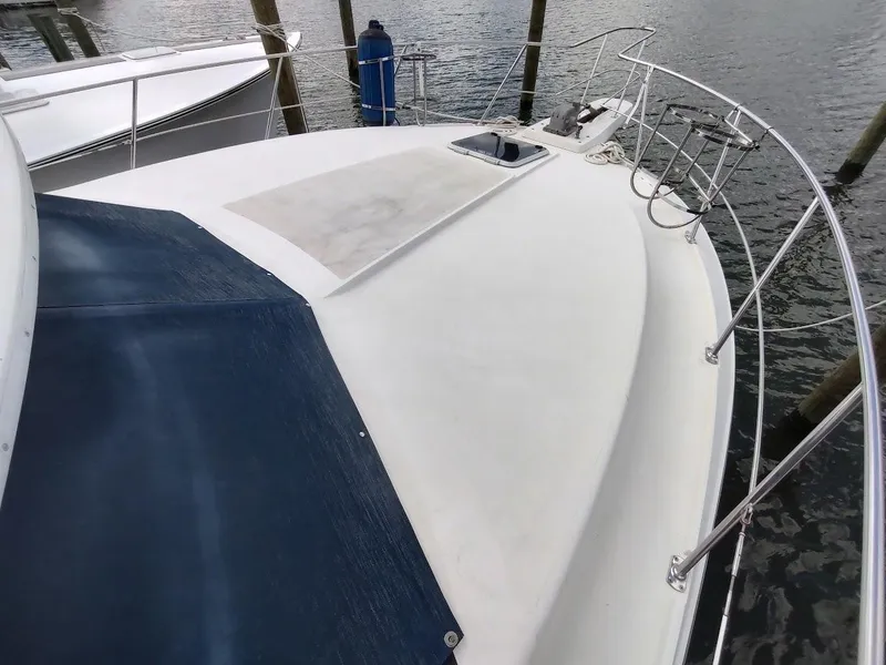 Slide: The Image of 1992 Carver 36 Aft Cabin yacht deck with railing, docked by the water. - 5