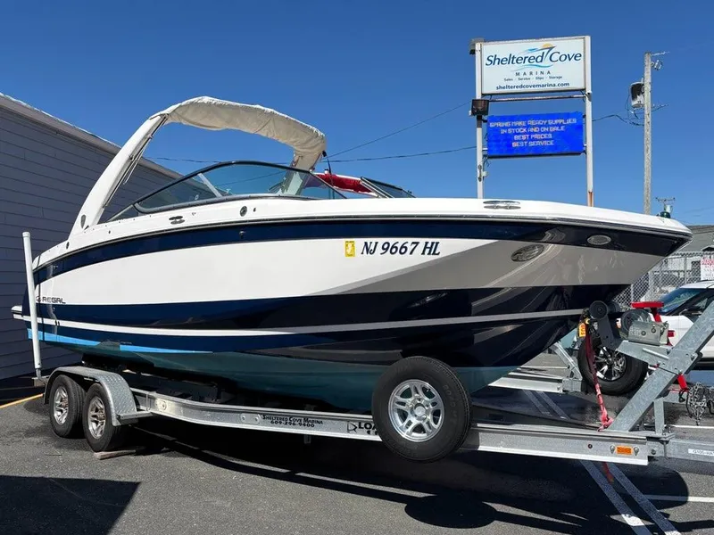 The Image of 2018 Regal 26 OBX boat on trailer at marina, with Yamaha signage. - 0