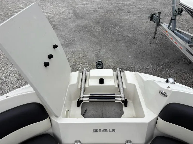 Slide: The Image of 2018 Stingray 214 LR boat with open storage compartment and ladder. - 10