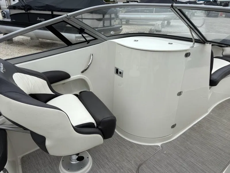 Slide: The Image of 2018 Stingray 214 LR boat interior with black and white seating and sleek design. - 13