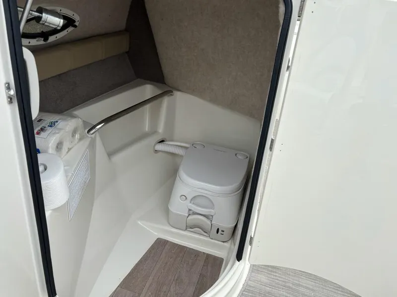Slide: The Image of Interior of a 2018 Stingray 214 LR boat featuring a compact toilet area. - 14