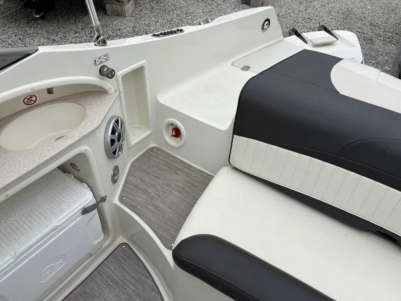 Slide: The Image of 2018 Stingray 214 LR boat interior with seating, sink, and storage. - 17