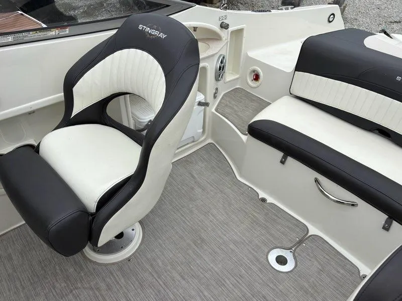 Slide: The Image of 2018 Stingray 214 LR boat interior with black and white seating and modern design. - 19