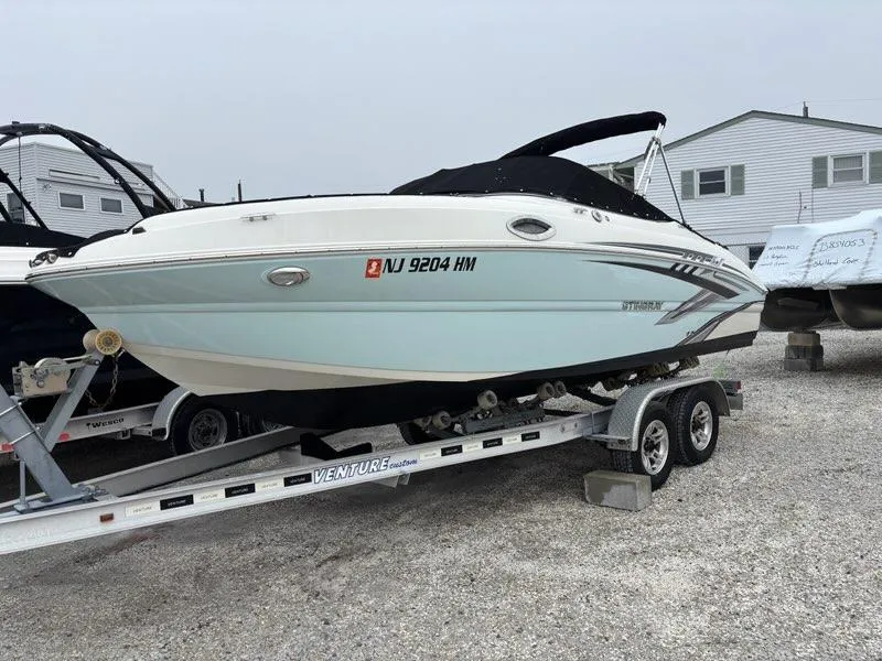 Slide: The Image of 2018 Stingray 214 LR boat on trailer, parked outdoors. - 4