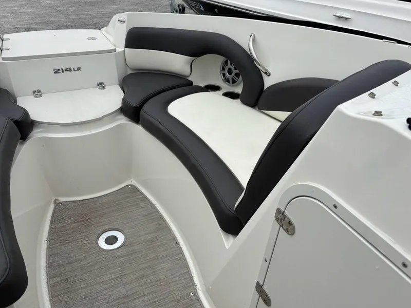 Slide: The Image of 2018 Stingray 214 LR boat interior with black and white seating and speaker. - 7
