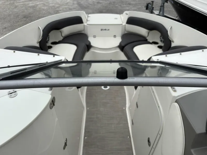 Slide: The Image of 2018 Stingray 214 LR boat interior with cushioned seating and windshield view. - 9