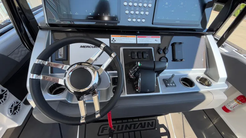 Slide: The Image of 2025 Fountain 34 SC boat dashboard with steering wheel, controls, and digital displays. - 33