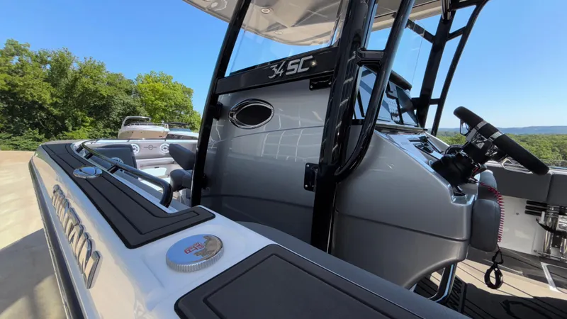 Slide: The Image of 2025 Fountain 34 SC boat cockpit with steering wheel, sleek design, and outdoor setting. - 36