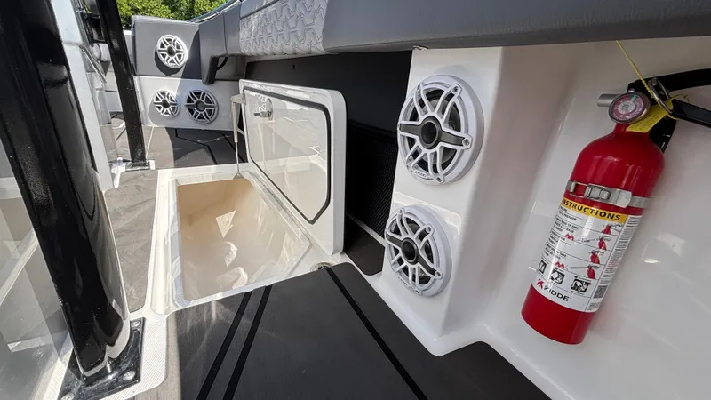 Slide: The Image of 2025 Fountain 34 SC boat interior with speakers, storage compartment, and fire extinguisher. - 41
