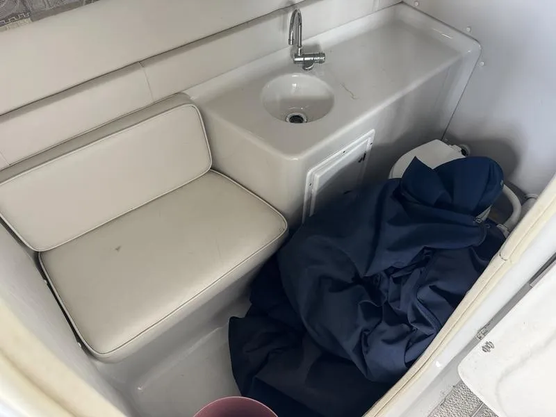 Slide: The Image of 2006 Crownline 290 BR boat interior with sink, seat, and storage area. - 13