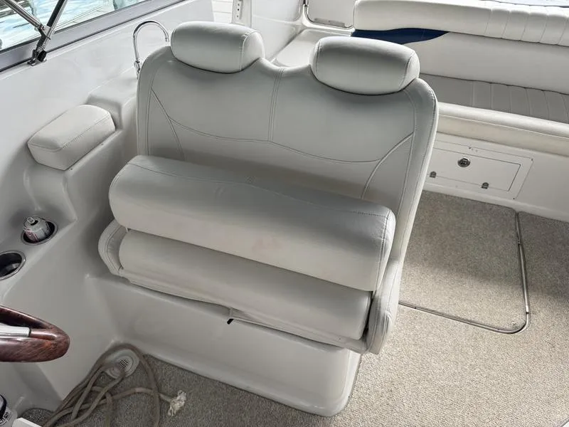Slide: The Image of 2006 Crownline 290 BR boat interior with white leather seating and carpeted flooring. - 16