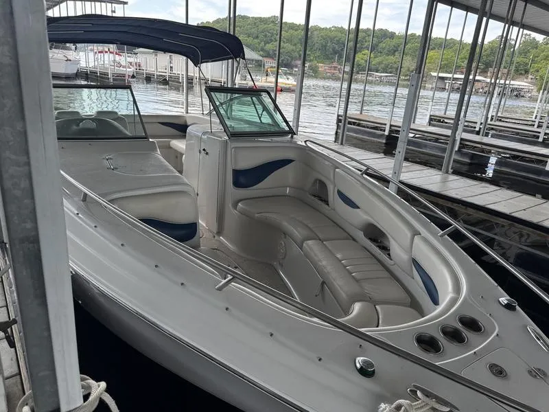 Slide: The Image of 2006 Crownline 290 BR boat docked in a marina, featuring spacious seating and canopy. - 7