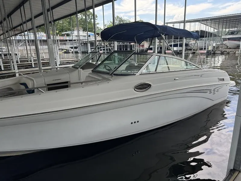 Slide: The Image of 2006 Crownline 290 BR boat docked in a marina, featuring sleek design and blue canopy. - 9
