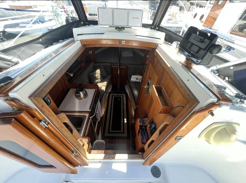 Slide: The Image of Interior view of 1986 Pacific Seacraft Dana 24 sailboat, showcasing cozy cabin and wooden finishes. - 11