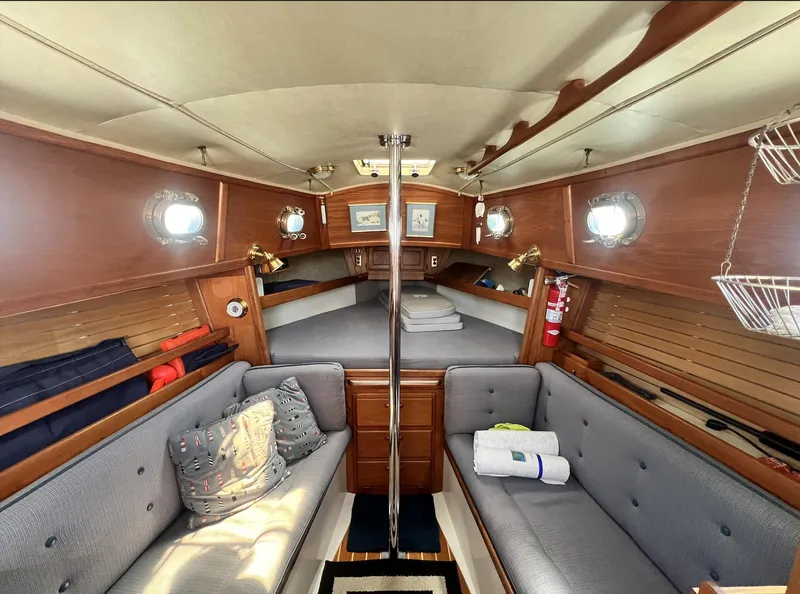 Slide: The Image of Interior of 1986 Pacific Seacraft Dana 24 sailboat with cozy seating and wooden accents. - 12