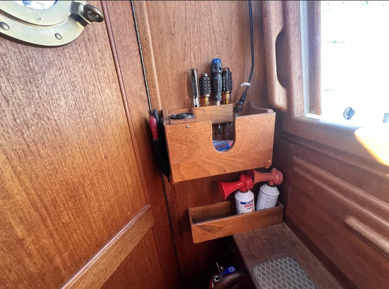 Slide: The Image of Wooden interior of 1986 Pacific Seacraft Dana 24 with tool storage and marine equipment. - 17