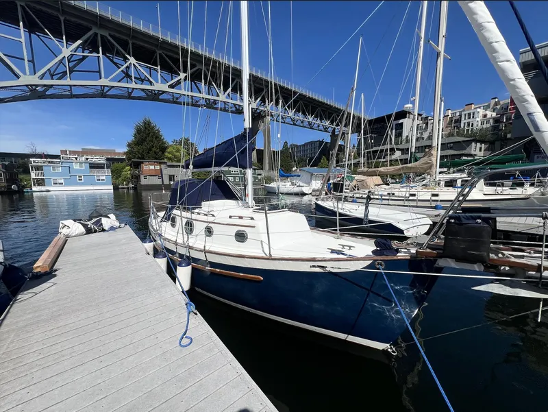 Slide: The Image of 1986 Pacific Seacraft Dana 24 sailboat docked under a bridge on a sunny day. - 2