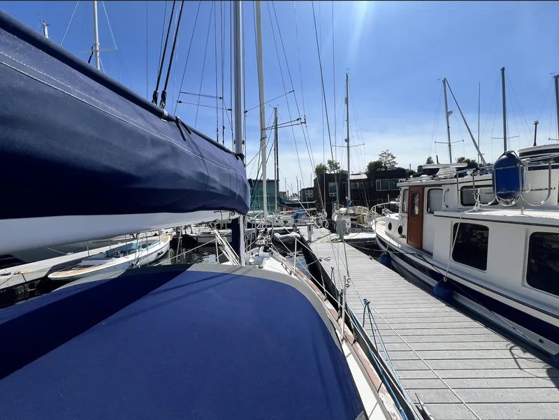 Slide: The Image of 1986 Pacific Seacraft Dana 24 sailboat docked at marina under clear blue sky. - 4