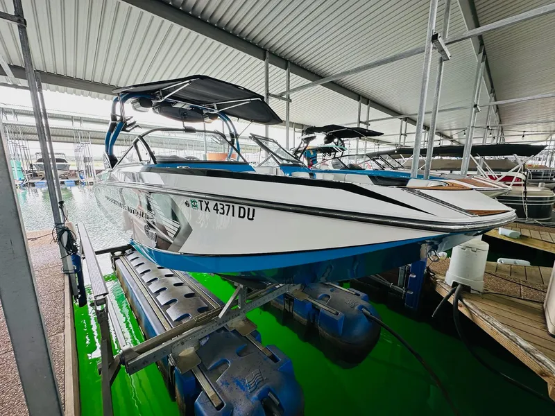 Slide: The Image of 2015 Nautique Super Air Nautique G23 boat docked in a covered marina. - 10