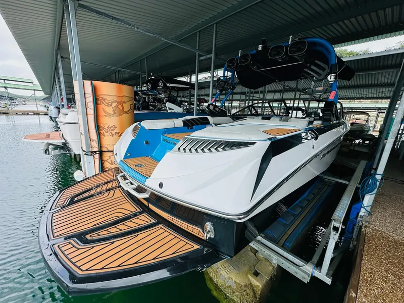 Slide: The Image of 2015 Nautique Super Air Nautique G23 boat docked in a covered marina. - 11