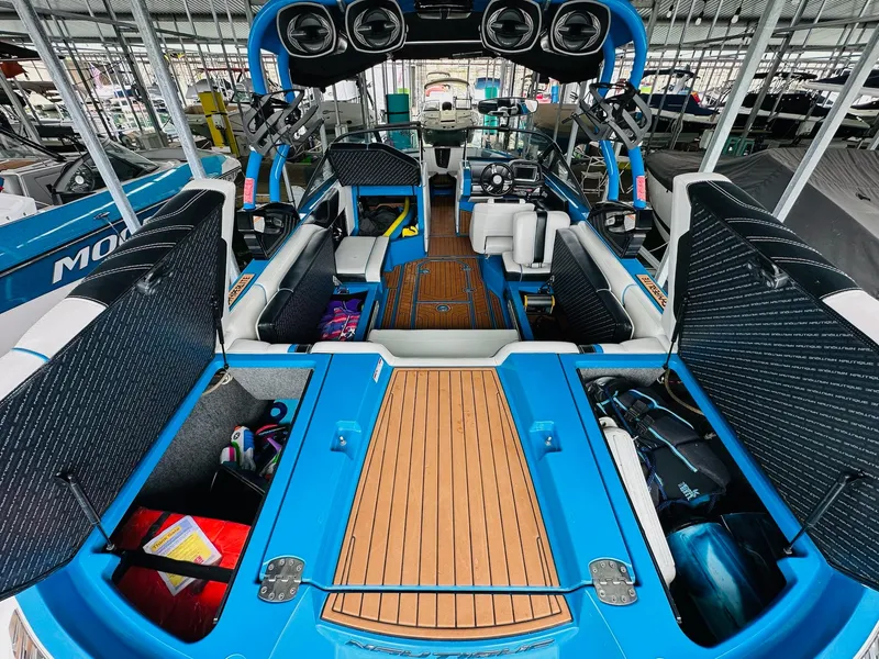 Slide: The Image of 2015 Nautique Super Air Nautique G23 interior with open storage compartments and seating. - 17