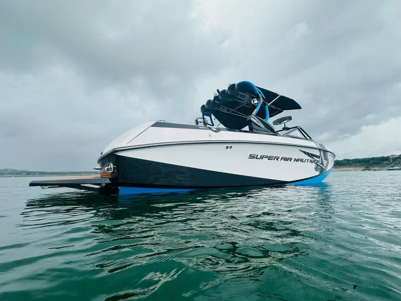 Slide: The Image of 2015 Nautique Super Air Nautique G23 boat on water under cloudy sky. - 2