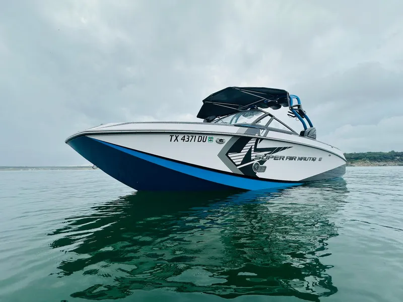 Slide: The Image of 2015 Nautique Super Air Nautique G23 boat on calm water under cloudy sky. - 3
