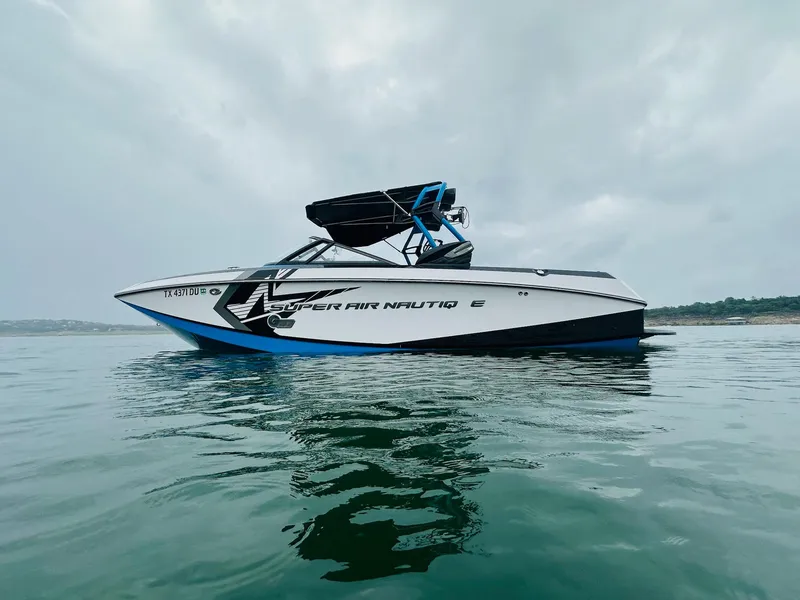 Slide: The Image of 2015 Nautique Super Air Nautique G23 boat on calm water under cloudy sky. - 4