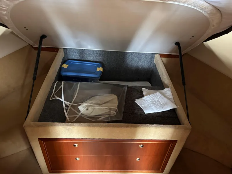 Slide: The Image of Open storage compartment in 2004 Riviera 4000 boat with various items inside. - 20