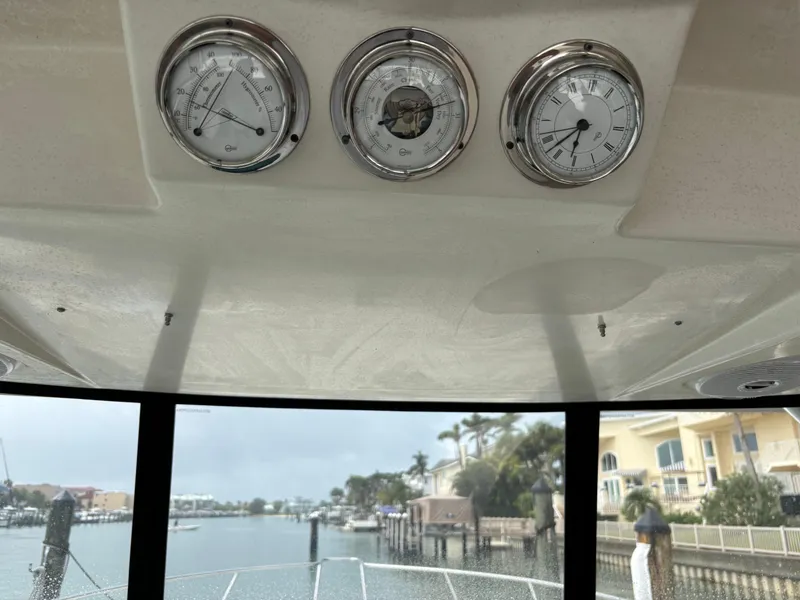 Slide: The Image of 2004 Riviera 4000 yacht dashboard with gauges, overlooking a marina view. - 27