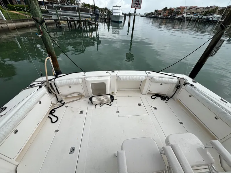 Slide: The Image of 2004 Riviera 4000 boat deck with seating, docked in a calm marina. - 32