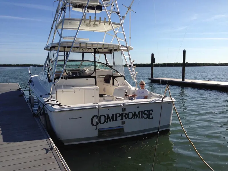 Slide: The Image of 2004 Riviera 4000 boat named "Compromise" docked with person seated onboard. - 4
