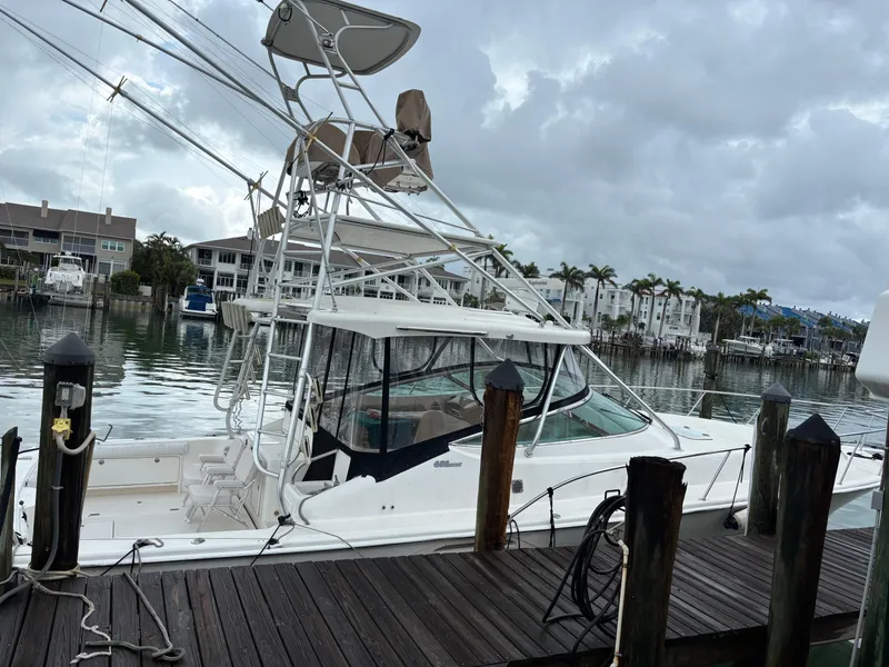 Slide: The Image of 2004 Riviera 4000 yacht docked at marina with cloudy sky backdrop. - 5