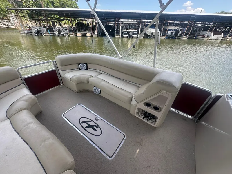 Slide: The Image of 2012 Harris FloteBote Grand Mariner SEL 250 interior with beige seating, docked by the water. - 13