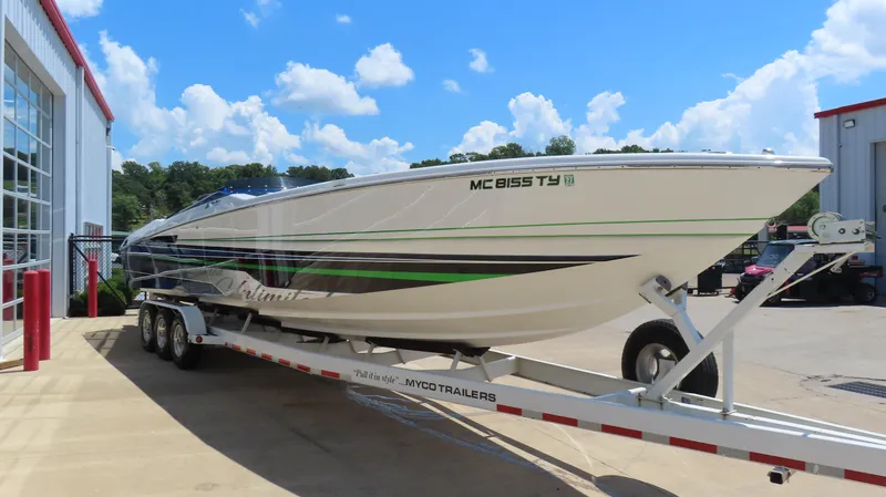 Slide: The Image of 2005 Cigarette 39' Top Gun Unlimited boat on trailer, parked outside a building. - 3