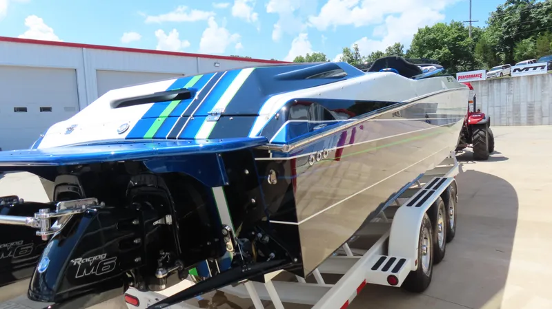 Slide: The Image of 2005 Cigarette 39' Top Gun Unlimited boat on trailer, featuring sleek design and vibrant stripes. - 4