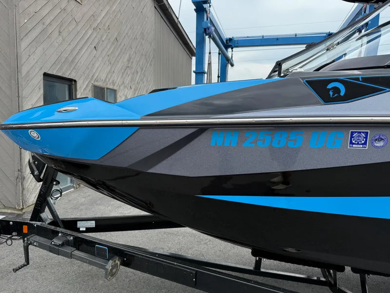 Slide: The Image of 2023 Centurion Fi23 boat with blue and black design on a trailer. - 10