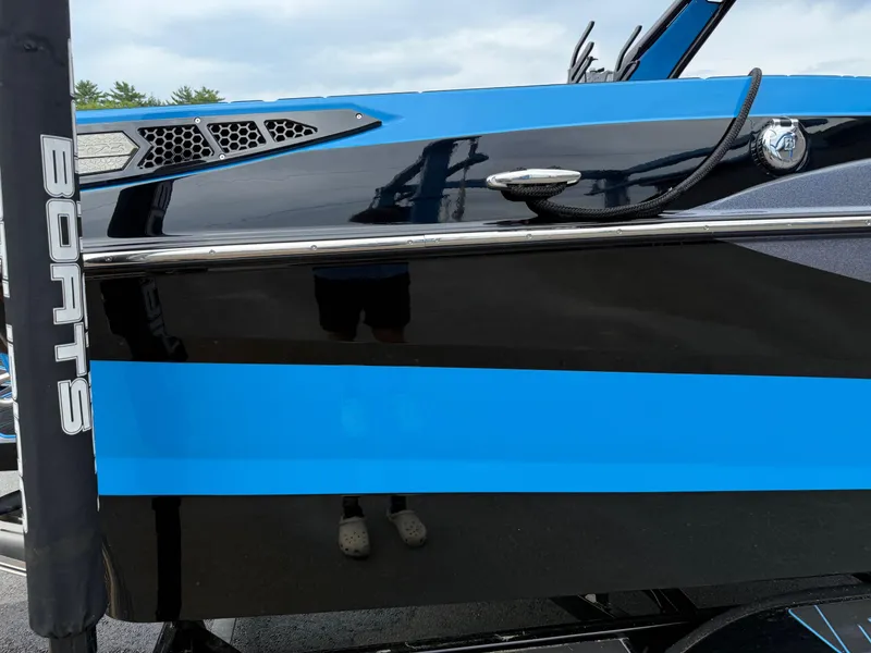 Slide: The Image of 2023 Centurion Fi23 boat with sleek black and blue design. - 12