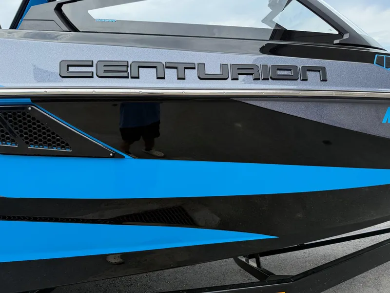 Slide: The Image of 2023 Centurion Fi23 boat with sleek black and blue design. - 14