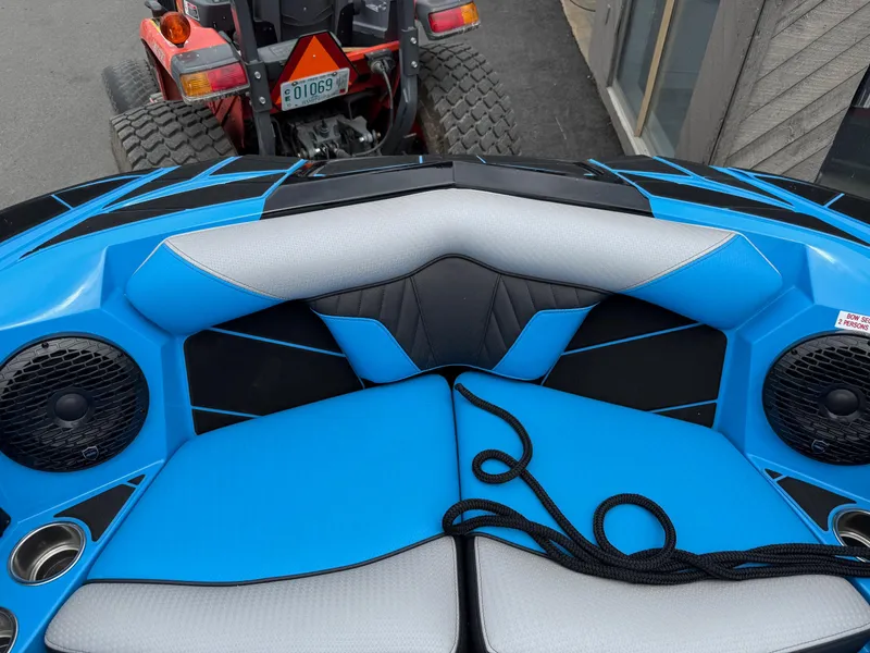 Slide: The Image of 2023 Centurion Fi23 boat interior with blue and black seating, speakers, and cup holders. - 17