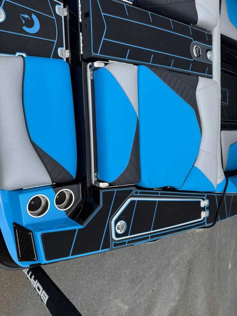 Slide: The Image of 2023 Centurion Fi23 boat interior with blue and gray seating, cup holders, and sleek design. - 18