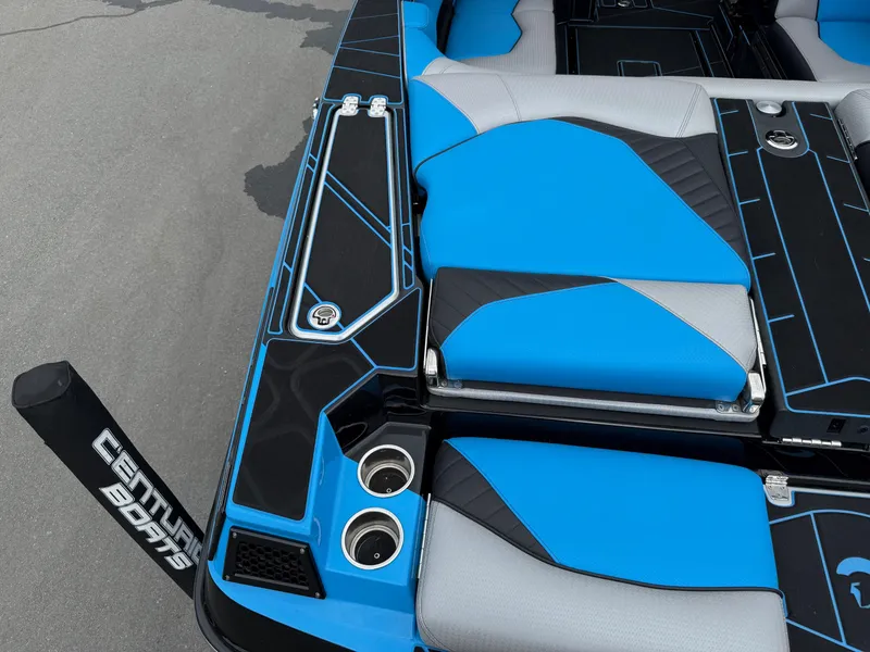 Slide: The Image of 2023 Centurion Fi23 boat interior with blue and gray seating, cup holders, and sleek design. - 19