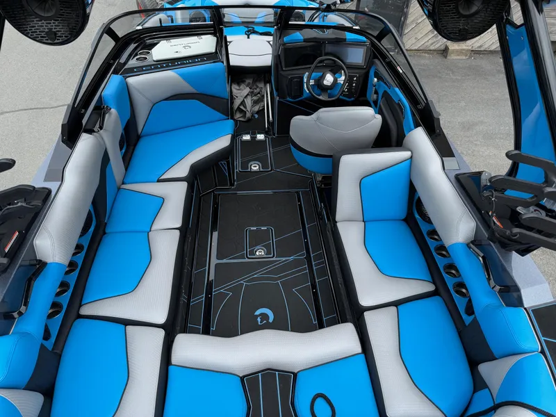 Slide: The Image of 2023 Centurion Fi23 boat interior with blue and gray seating, modern dashboard, and spacious layout. - 5