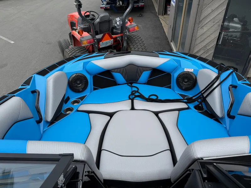 Slide: The Image of 2023 Centurion Fi23 boat interior with blue and gray seating, cup holders, and speakers. - 6