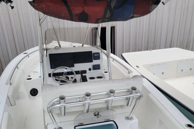 Slide: The Image of 2016 Sea Hunt Ultra 234 boat interior with steering console and rod holders. - 2