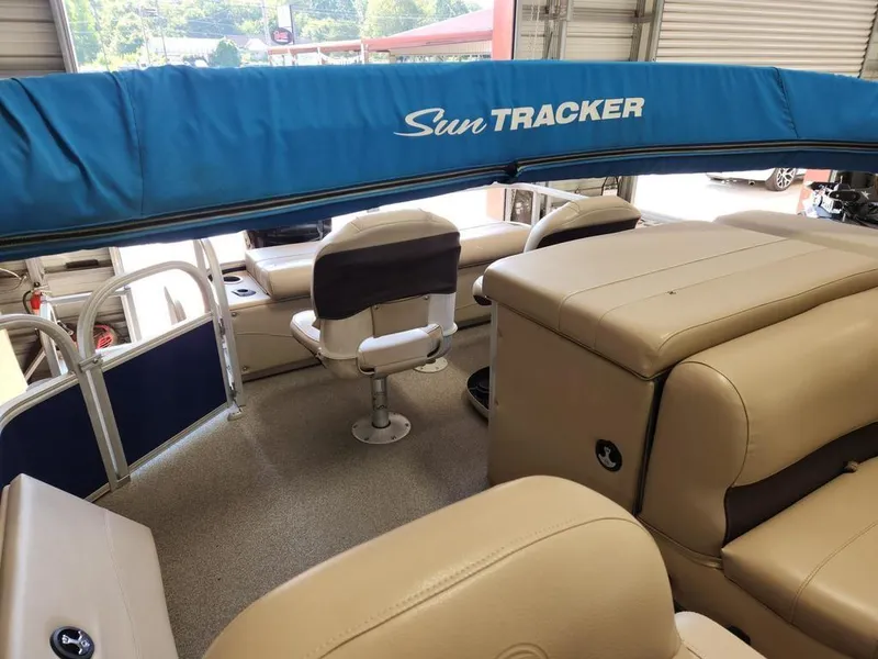 Slide: The Image of 2017 Sun Tracker FISHIN' BARGE® 24 DLX interior with beige seating and blue canopy. - 10
