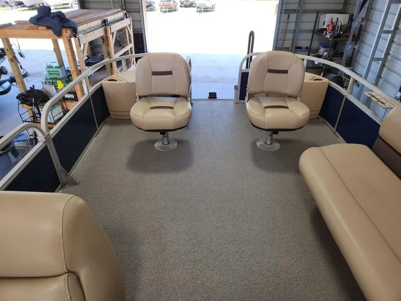 Slide: The Image of 2017 Sun Tracker FISHIN' BARGE® 24 DLX interior with beige seating in a garage setting. - 11