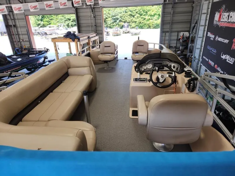 Slide: The Image of 2017 Sun Tracker FISHIN' BARGE® 24 DLX interior with beige seating and steering console. - 8