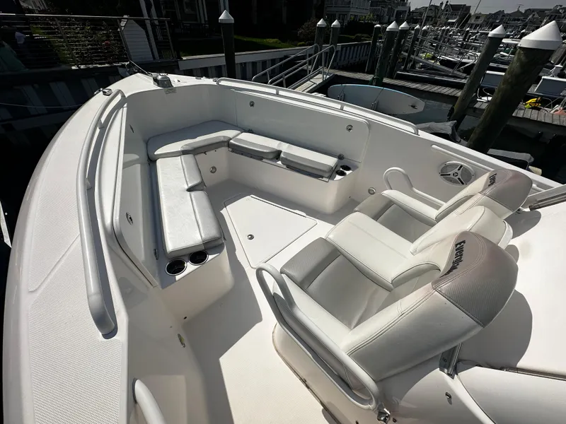Slide: The Image of 2012 Everglades 295 Center Console boat interior with white seating and cup holders. - 10
