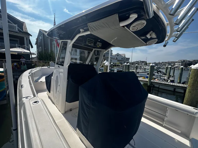 Slide: The Image of 2012 Everglades 295 Center Console boat docked at a marina, featuring covered seating. - 8